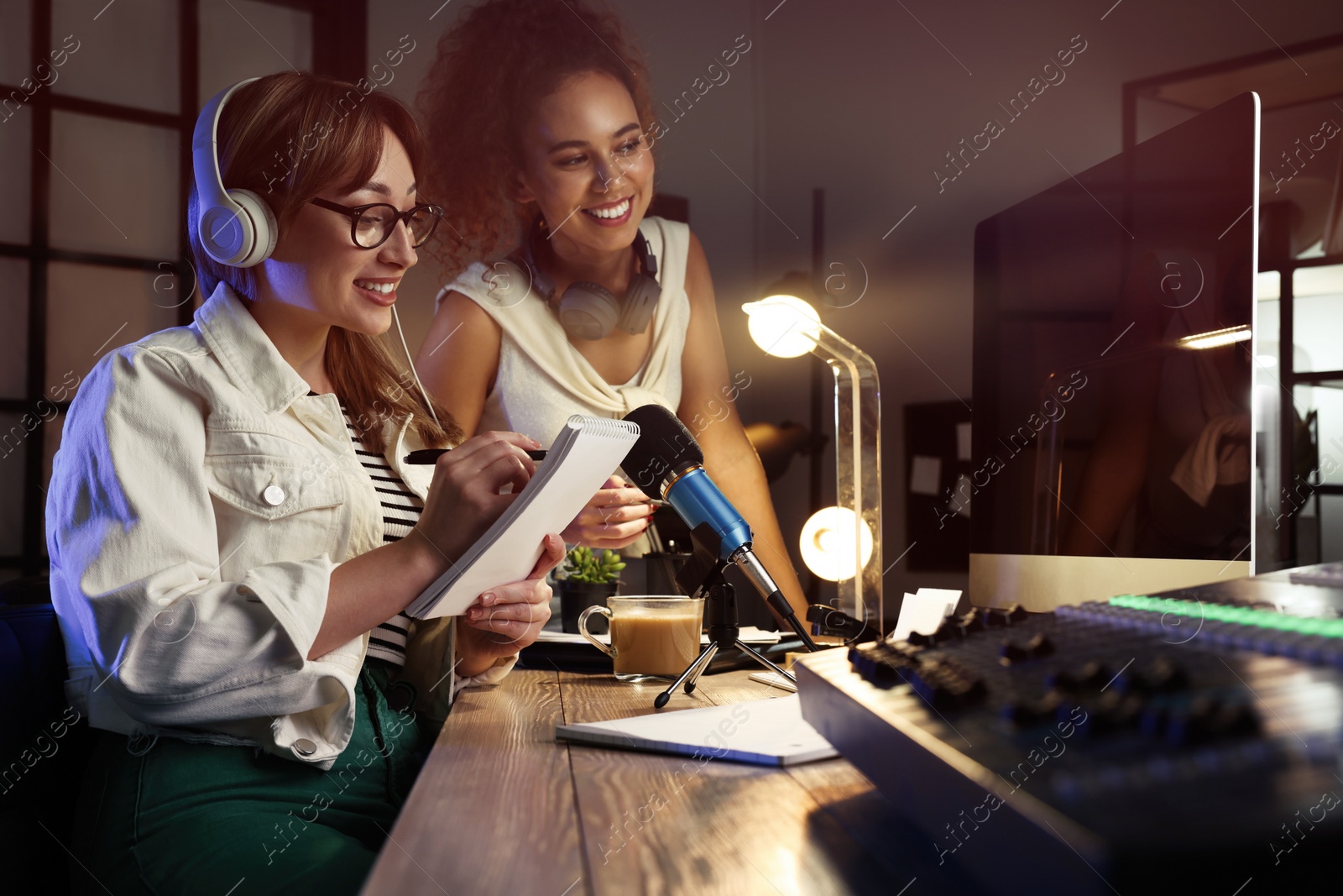 Photo of Young women working in modern radio studio