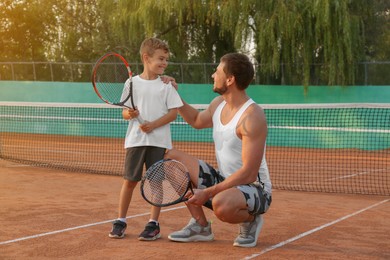 Father with his son on tennis court