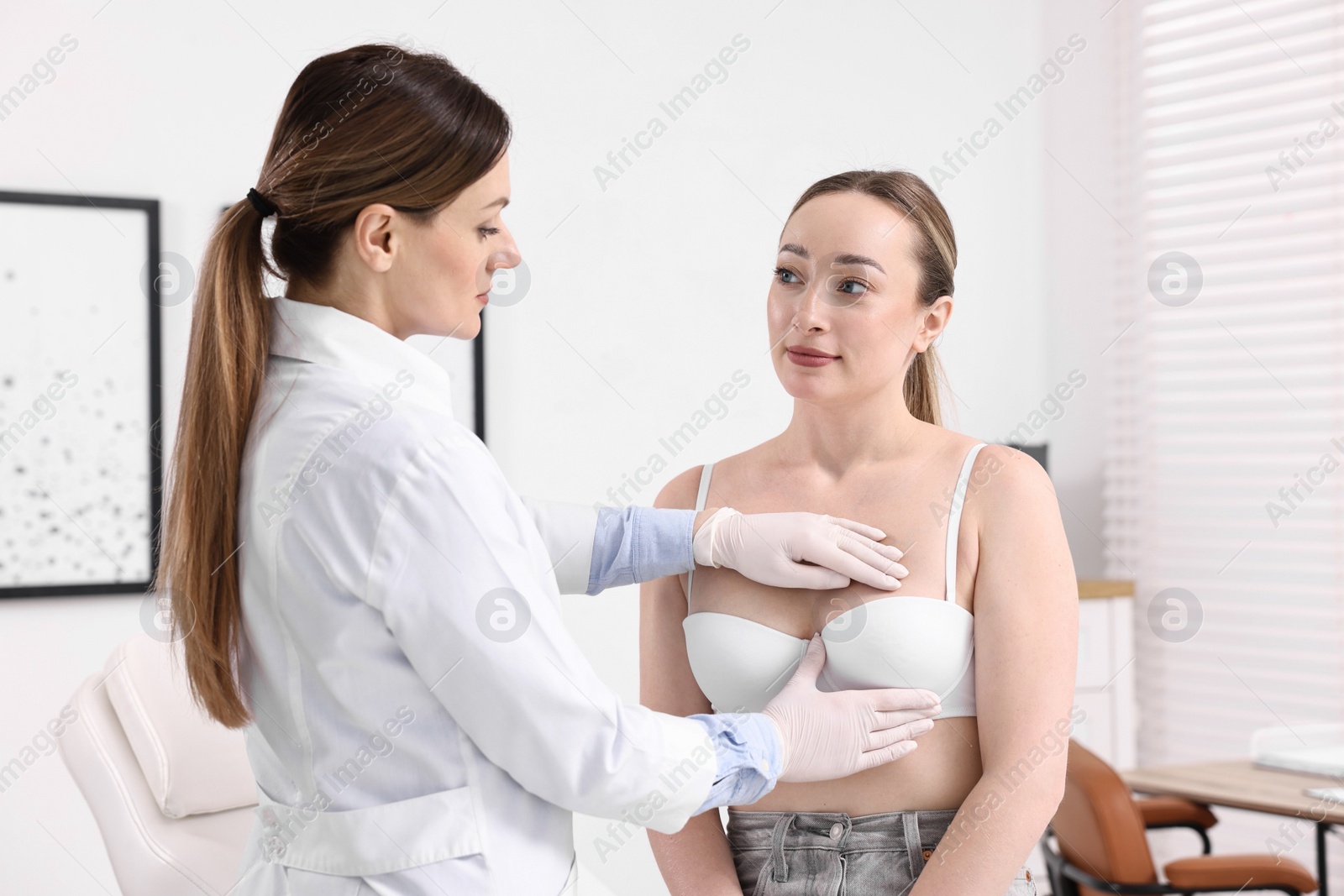 Photo of Mammologist checking young woman's breast in hospital