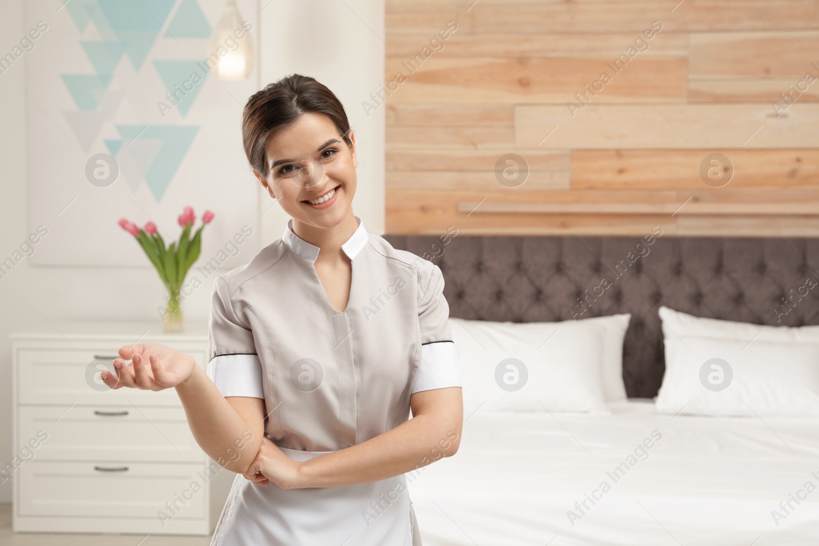 Photo of Portrait of young maid in hotel room. Space for text