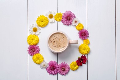 Photo of Beautiful floral composition with cup of hot coffee on white wooden background, flat lay