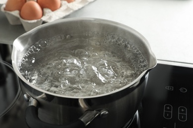 Photo of Pot with boiling water on stove, closeup