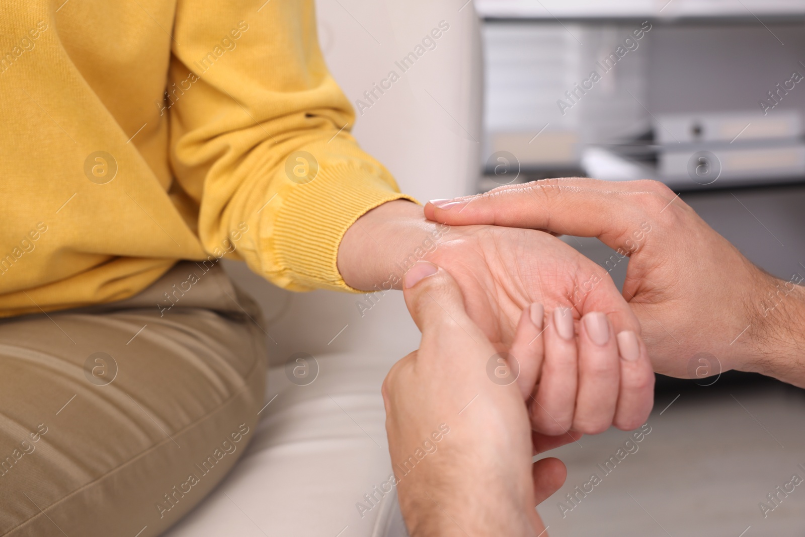 Photo of Doctor checking patient's pulse in clinic, closeup