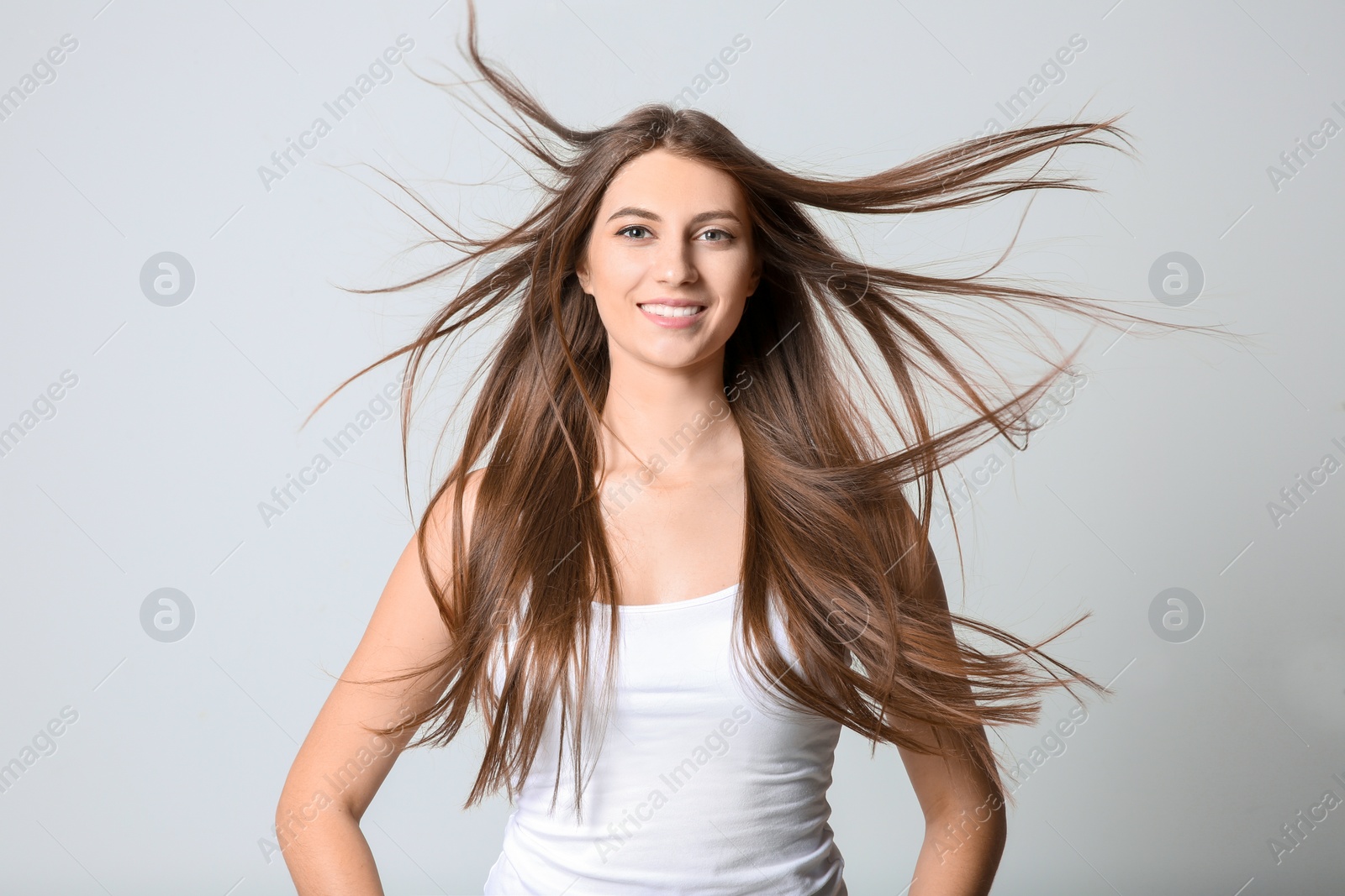 Photo of Portrait of young woman with long beautiful hair on light background