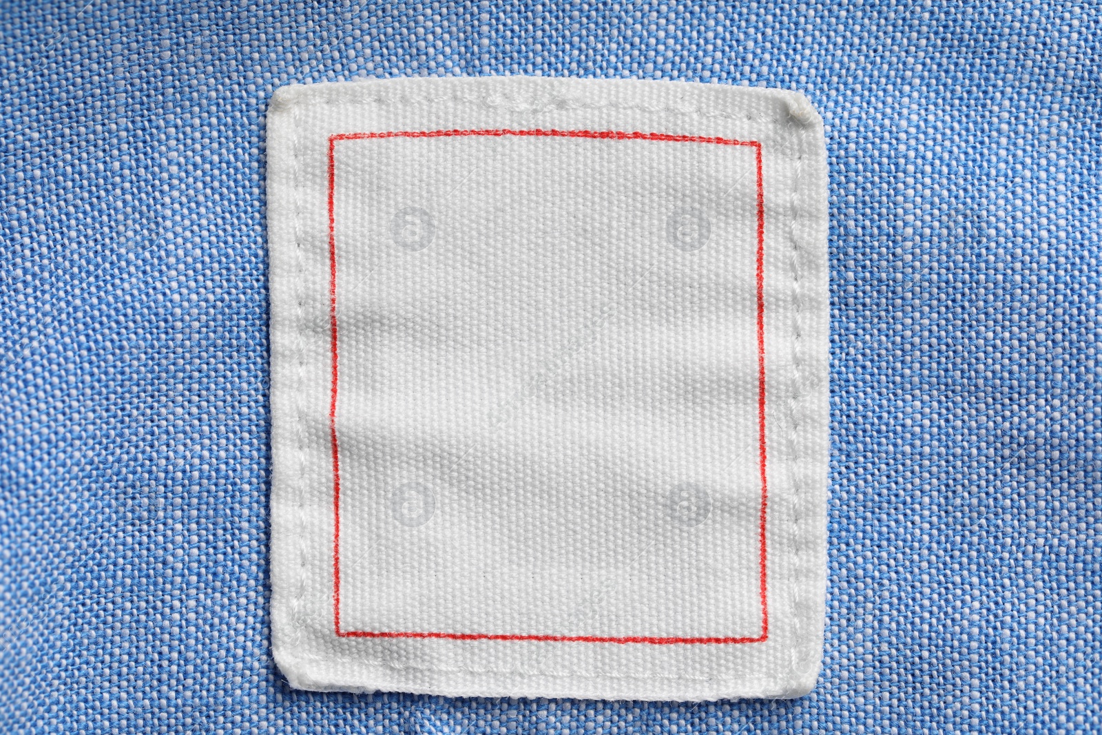 Photo of Clothing label on light blue garment, top view