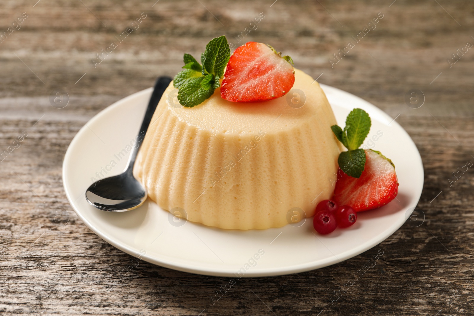 Photo of Delicious semolina pudding with berries on wooden table