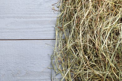 Photo of Heap of dried hay on grey wooden table, top view. Space for text