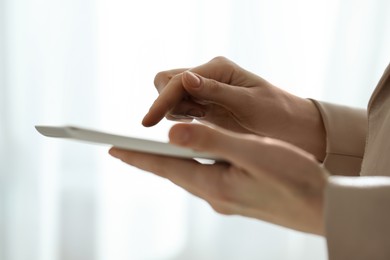 Photo of Closeup view of woman using modern tablet on blurred background