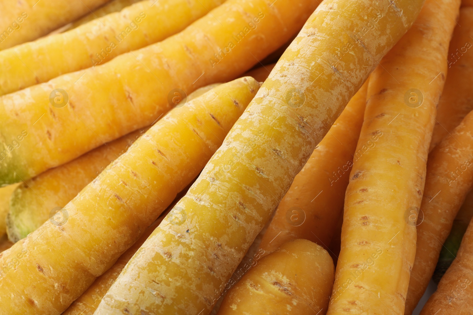 Photo of Fresh raw yellow carrots as background, closeup