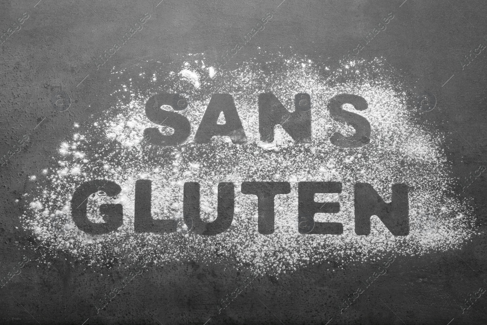 Photo of Words Sans gluten written with flour on grey background, top view