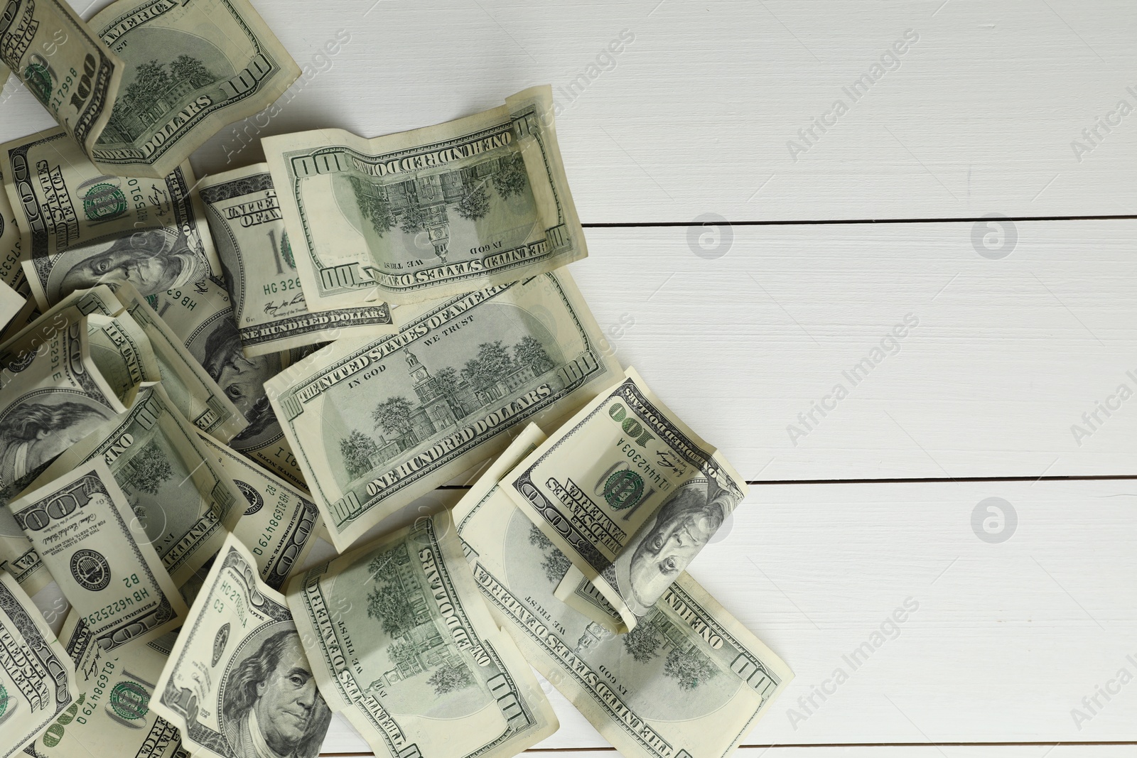 Photo of Money exchange. Dollar banknotes on white wooden background, top view. Space for text