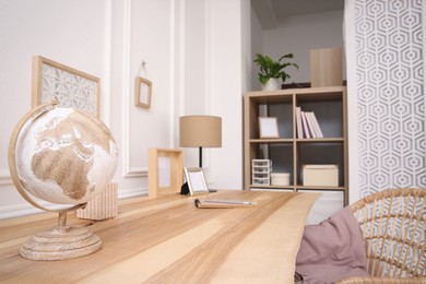 Photo of Wooden table with desk lamp in room. Interior design