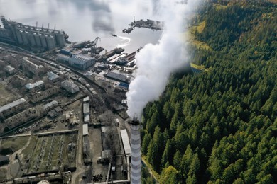 Image of Environmental pollution. Collage divided with smoke into mountain landscape and industrial factory