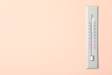 Photo of Weather thermometer on pink wall. Space for text