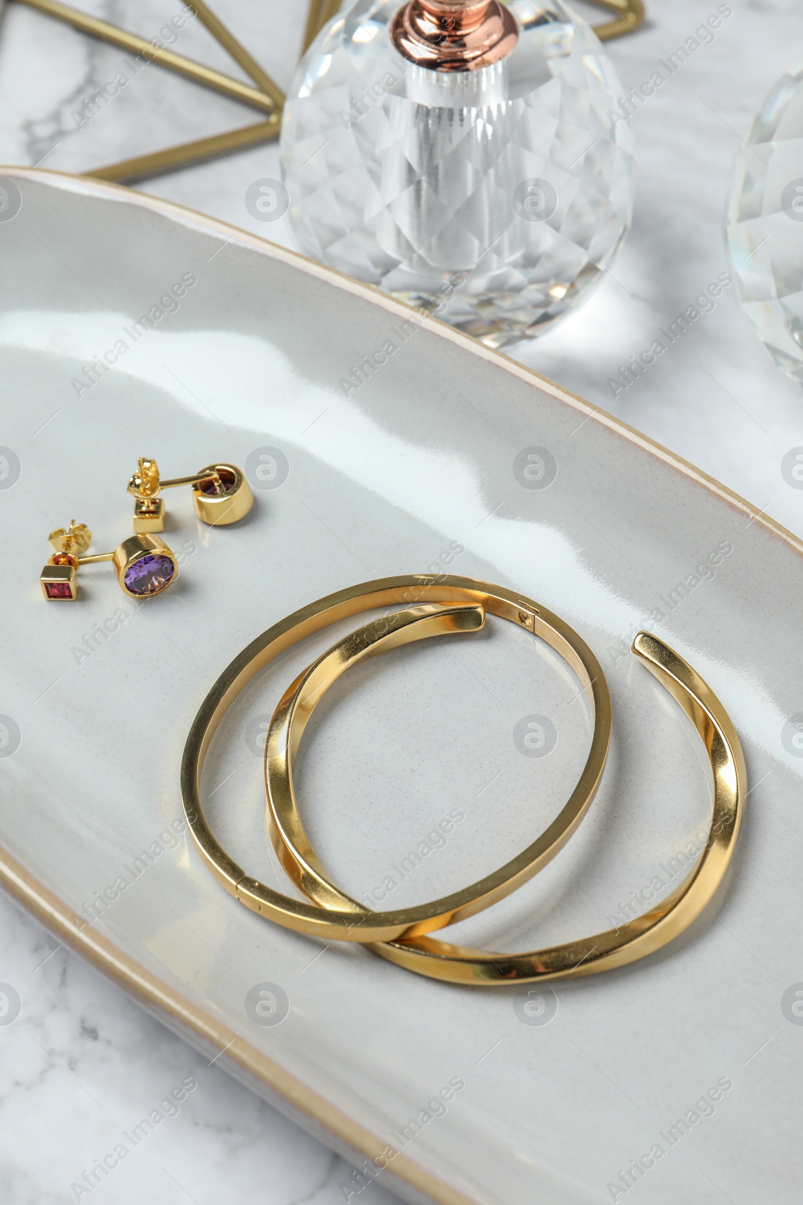 Photo of Elegant bracelets and earrings on white table