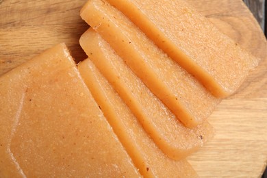 Photo of Tasty sweet quince paste on wooden board, top view