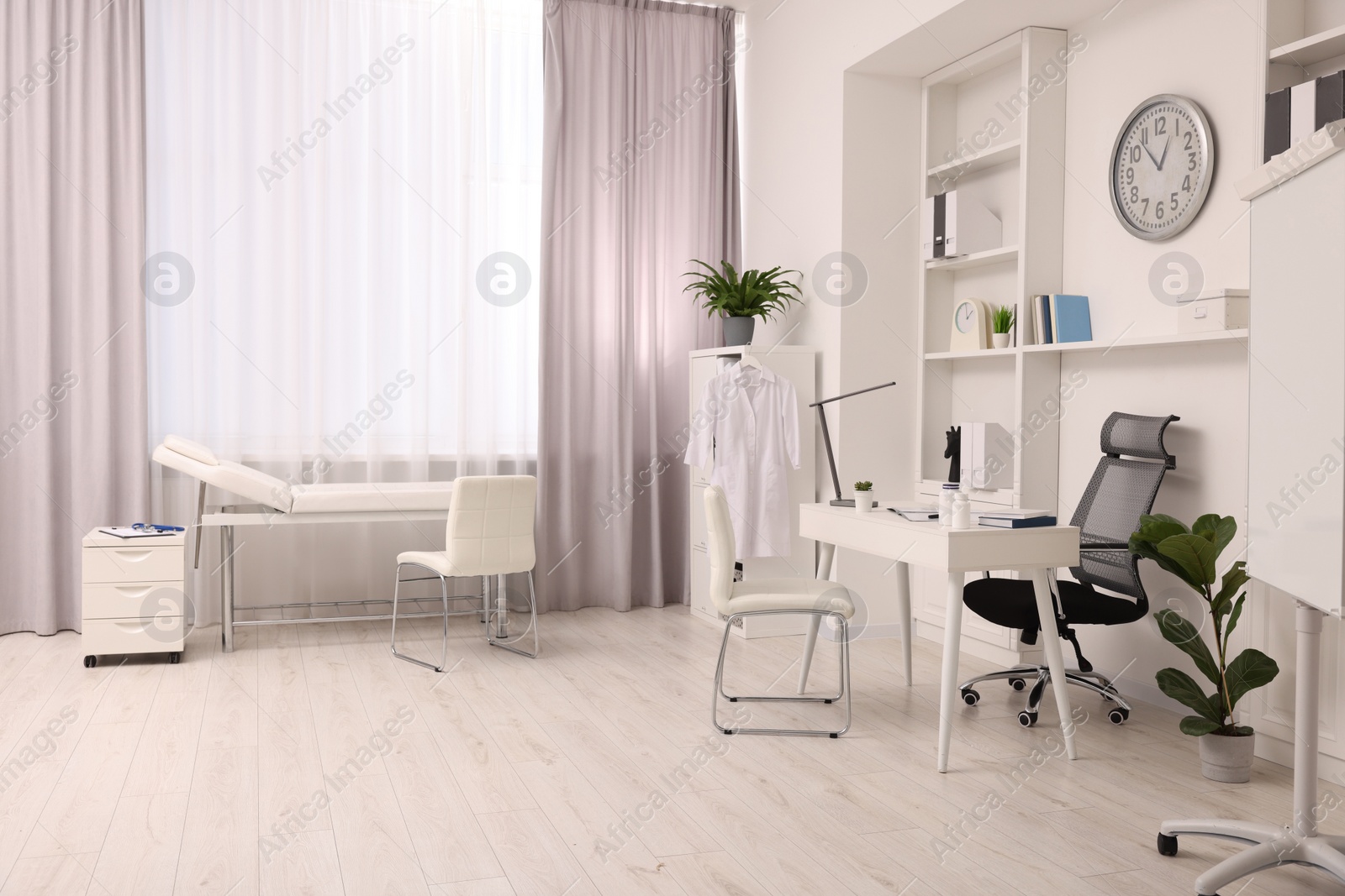 Photo of Modern medical office interior with doctor's workplace and examination table