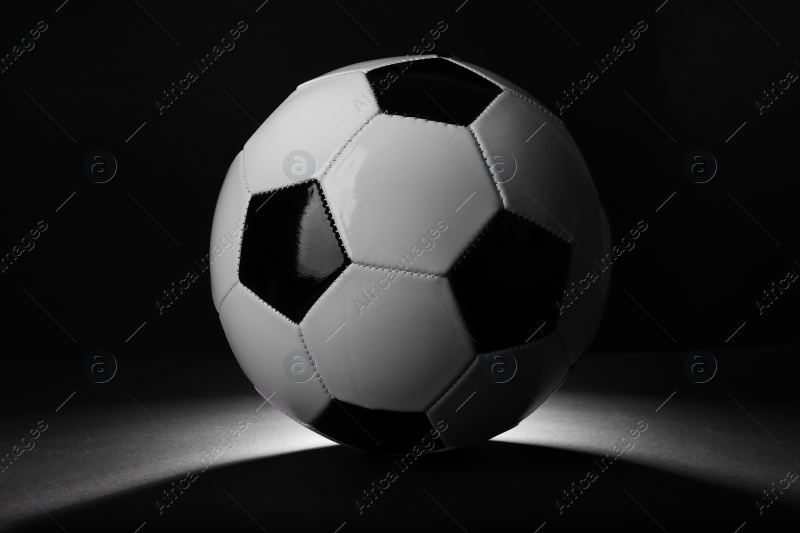 Photo of One soccer ball in darkness. Sports equipment
