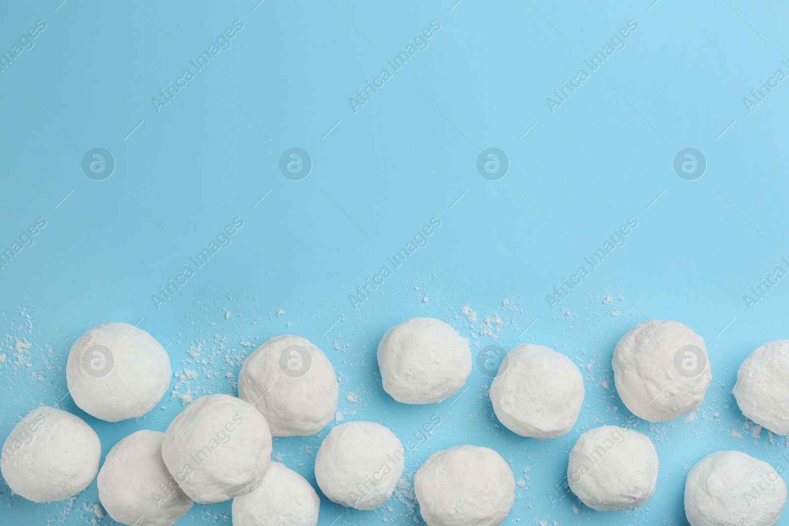 Photo of Snowballs on light blue background, flat lay. Space for text
