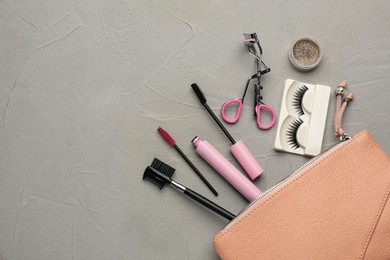 Flat lay composition with eyelash curler, makeup products and accessories on grey table. Space for text