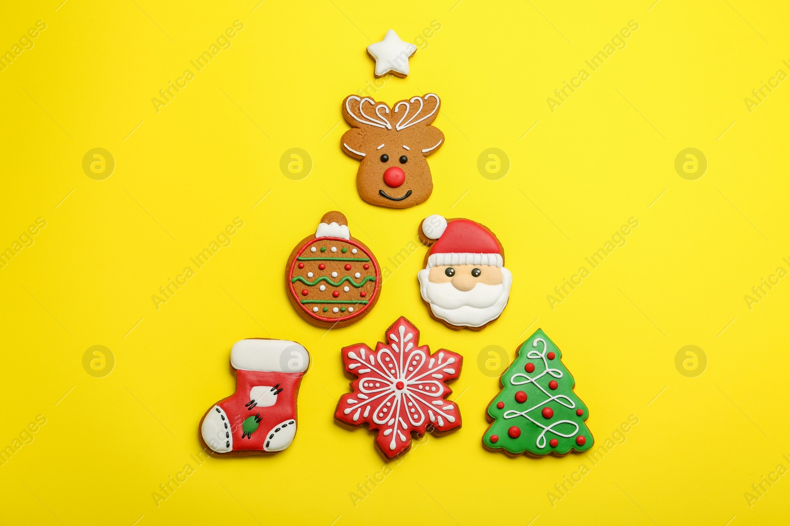 Photo of Different tasty Christmas cookies on yellow background, flat lay