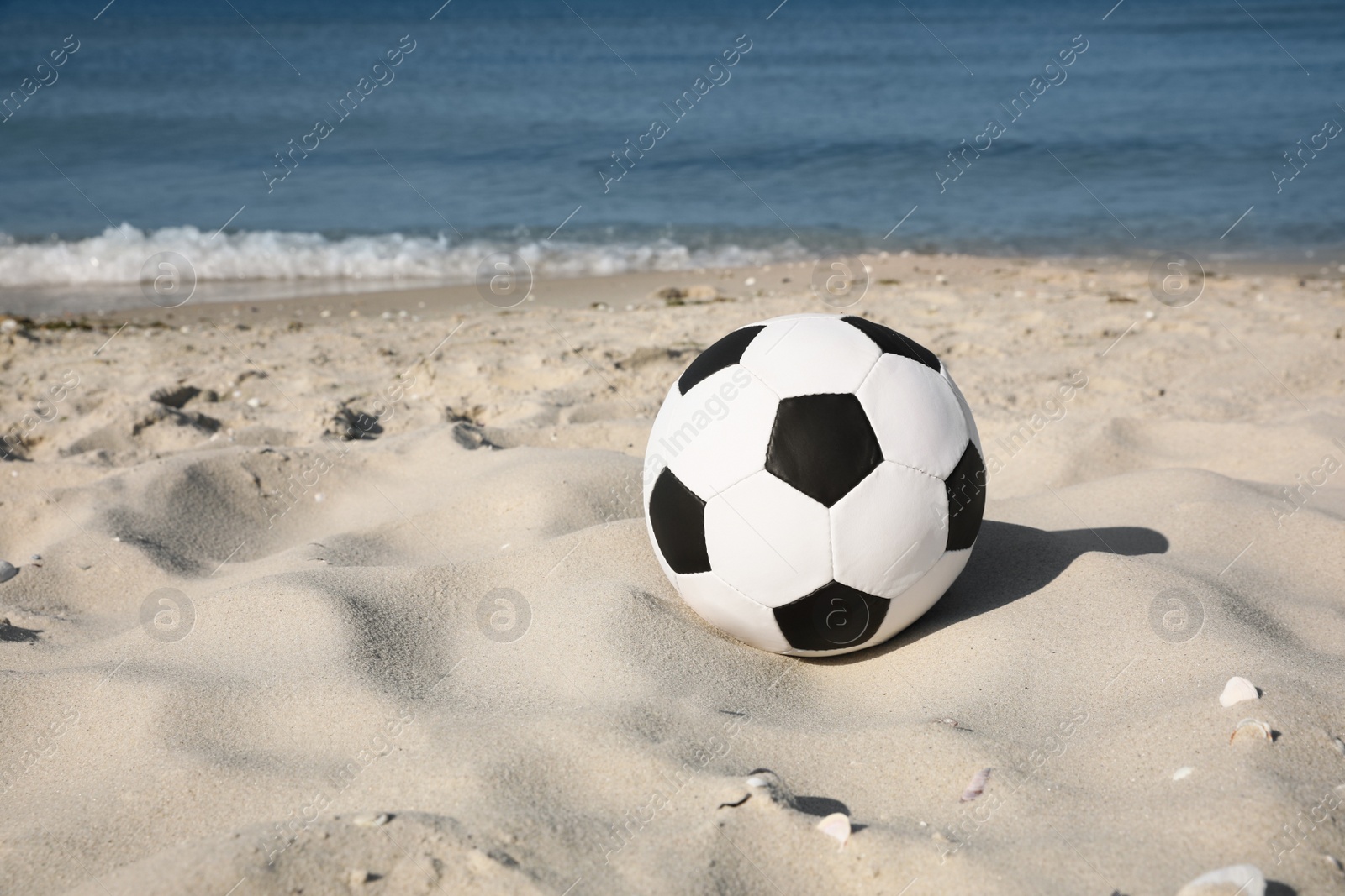 Photo of Soccer ball on beach, space for text. Football equipment