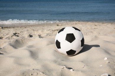 Soccer ball on beach, space for text. Football equipment