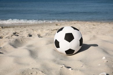 Photo of Soccer ball on beach, space for text. Football equipment