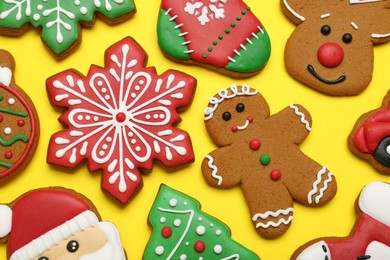 Photo of Different tasty Christmas cookies on yellow background, flat lay