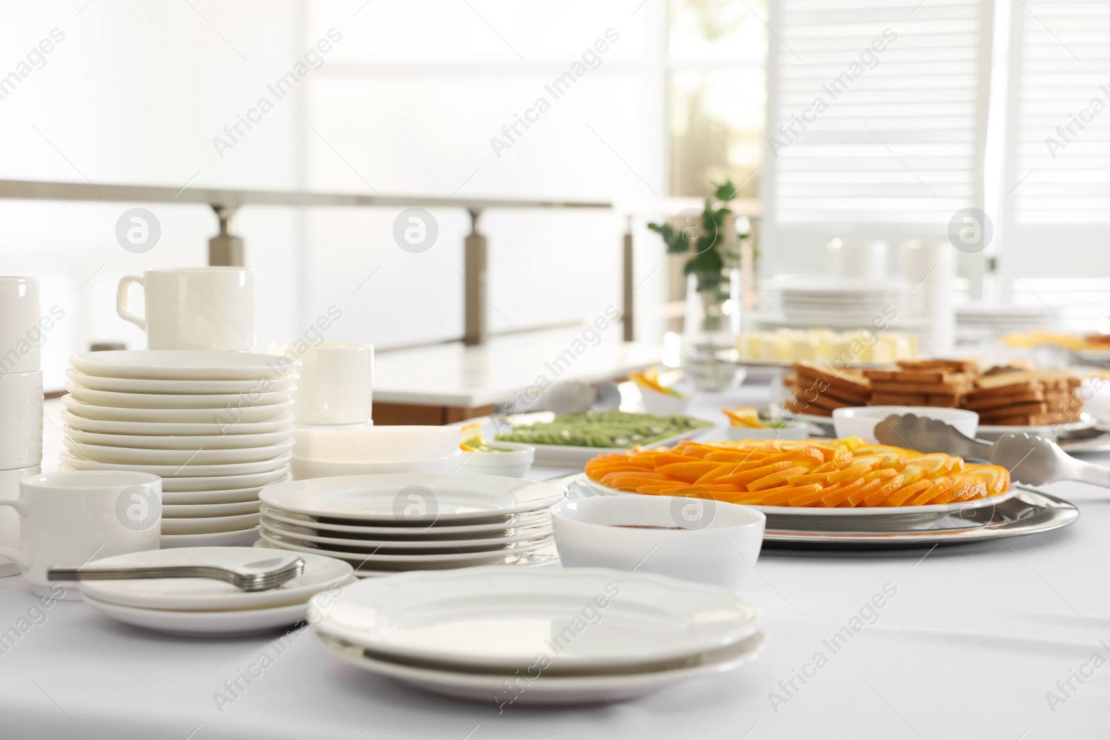 Photo of Clean dishware and different meals for breakfast on white table indoors. Buffet service