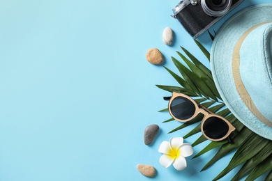 Photo of Flat lay composition with stylish beach accessories on light blue background, space for text