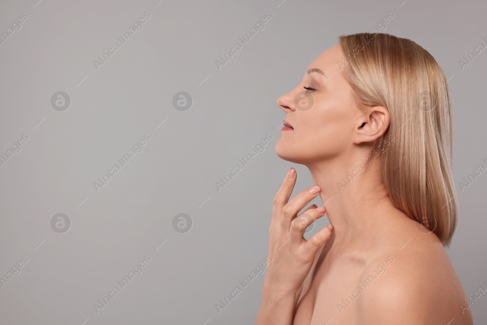 Photo of Beautiful woman touching her neck on grey background. Space for text