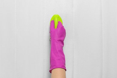 Photo of Woman in purple gloves cleaning white mattress with brush, top view