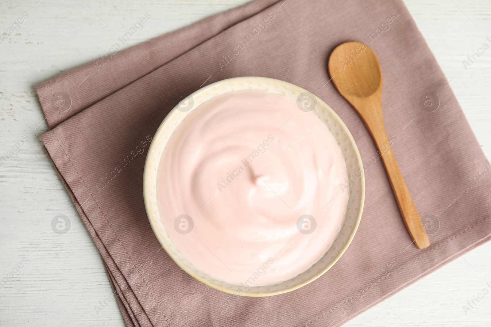 Photo of Tasty organic yogurt on white wooden table, top view