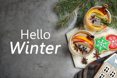 Image of Hello Winter greeting card. Flat lay composition with aromatic white mulled wine on grey table