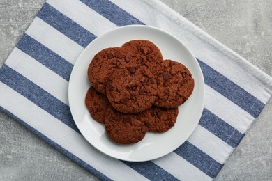 Delicious chocolate chip cookies on light grey table, top view