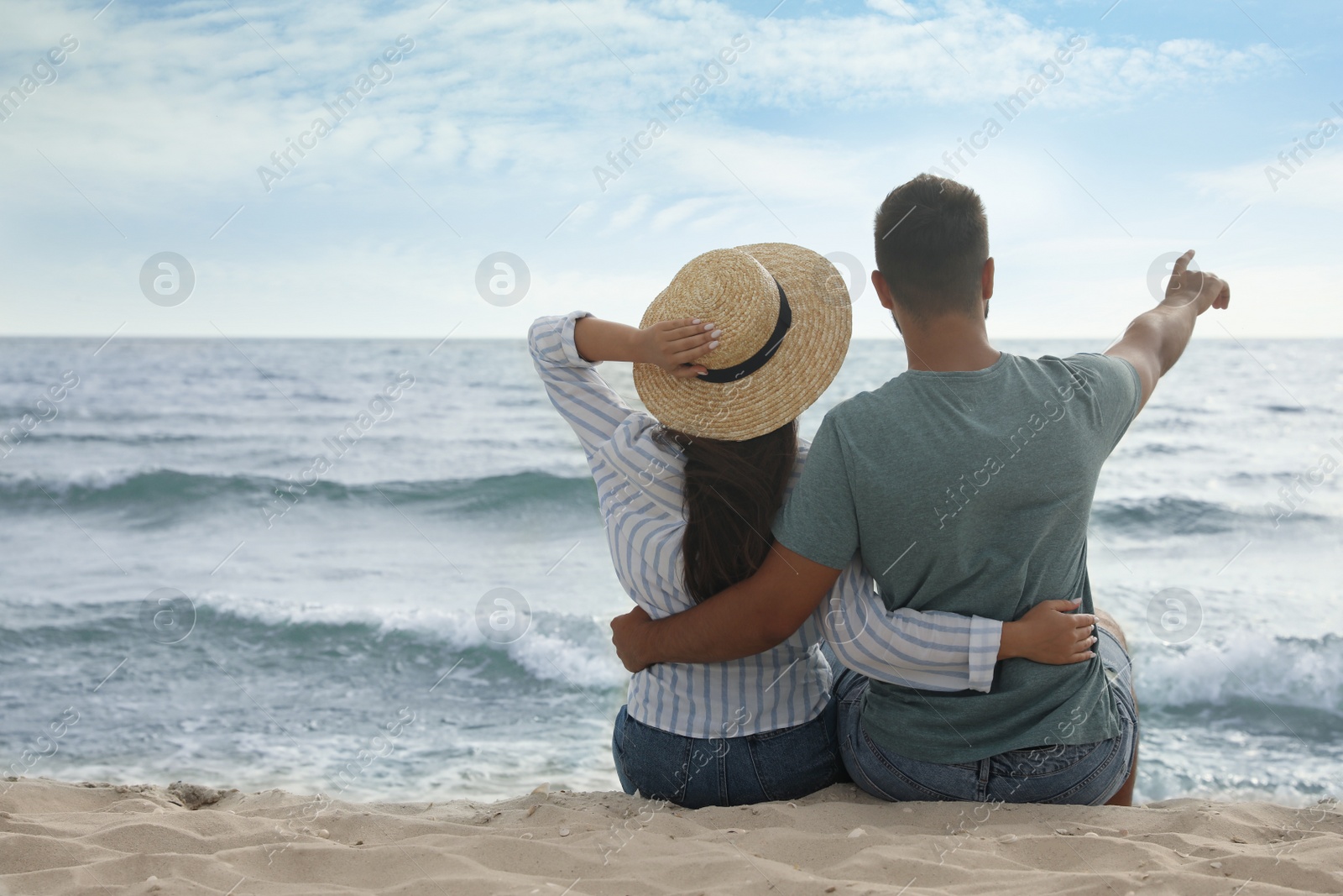 Photo of Lovely couple spending time together on beach, back view