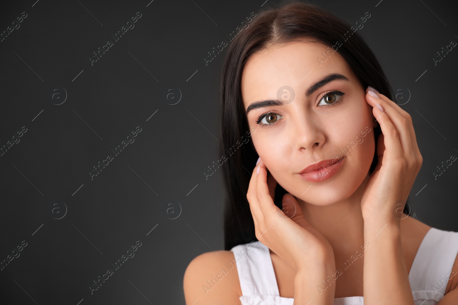 Photo of Portrait of beautiful young woman on dark grey background. Space for text