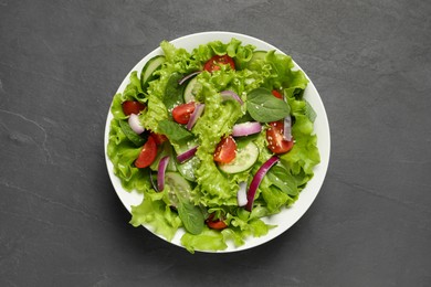 Photo of Delicious salad in bowl on grey table, top view