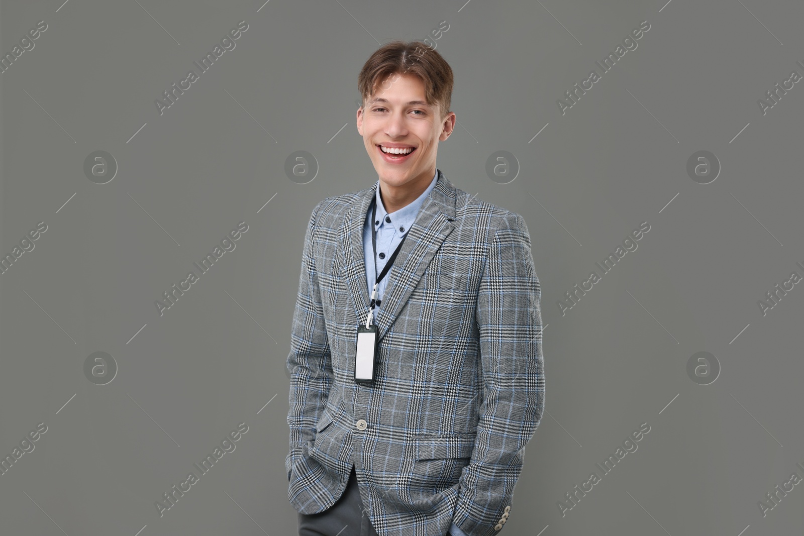 Photo of Happy man with blank badge on grey background