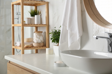 Shelving unit with toiletries in bathroom interior