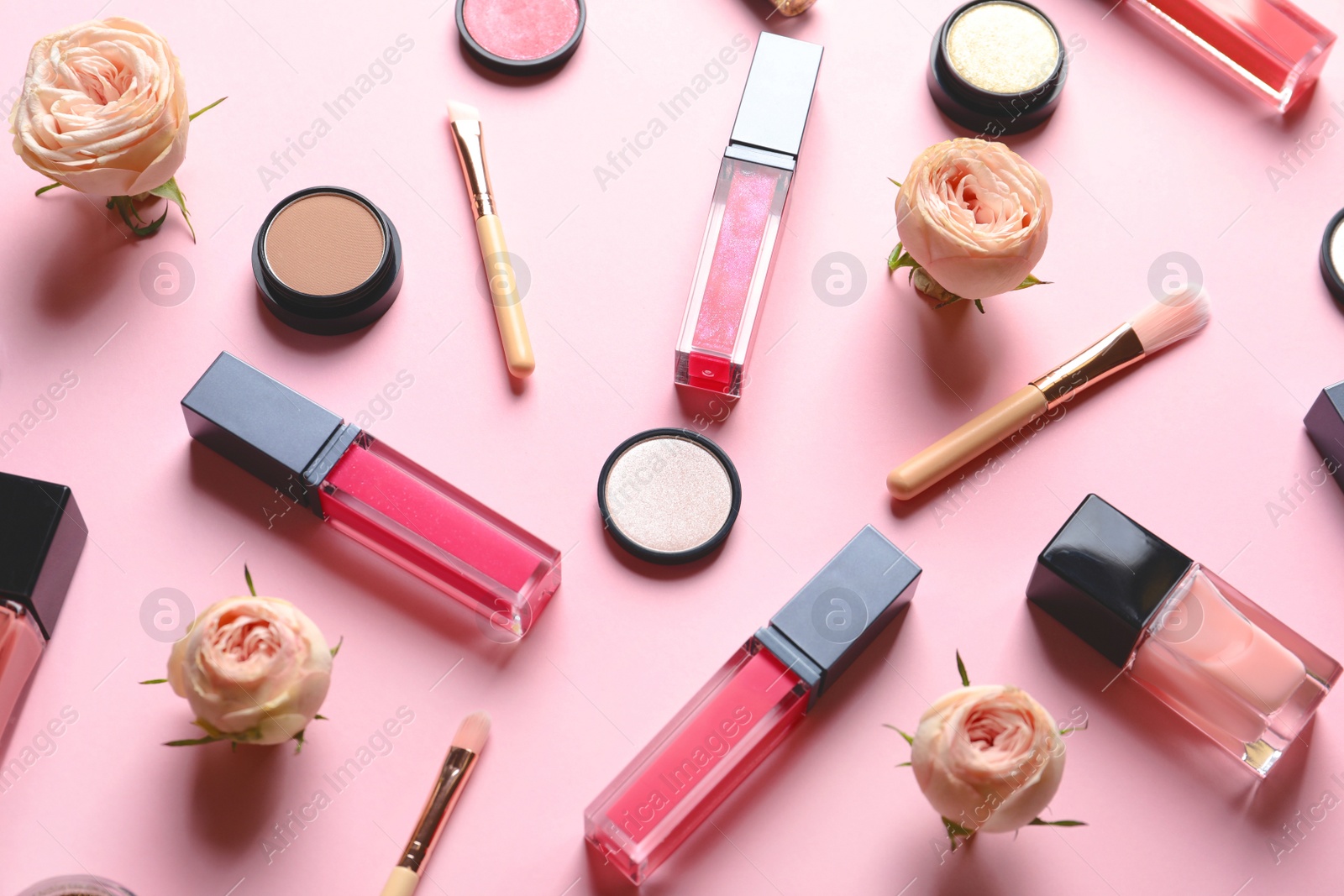 Photo of Beautiful composition with liquid lipsticks and flowers on color background