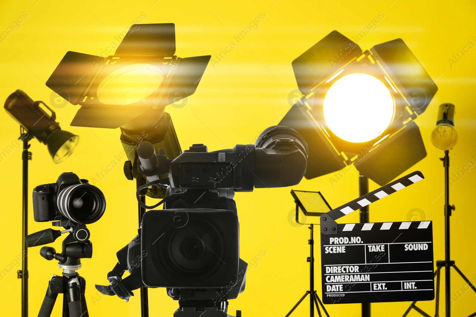 Image of Modern professional video camera and lighting equipment in studio