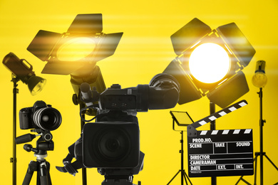 Modern professional video camera and lighting equipment in studio