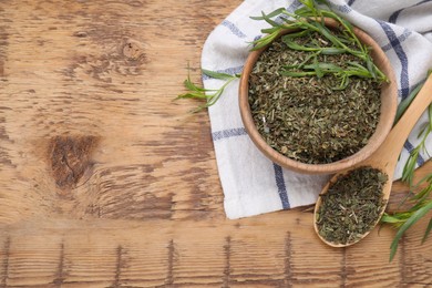 Photo of Dry and fresh tarragon on wooden table, flat lay. Space for text