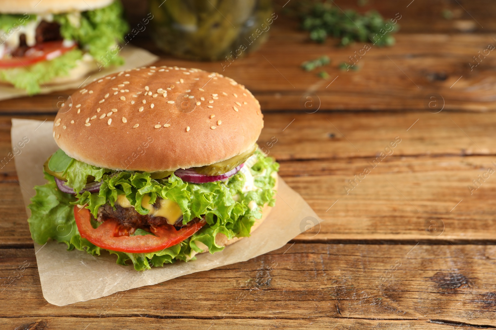 Photo of Delicious burger with beef patty on wooden table, space for text