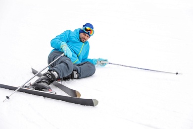 Photo of Clumsy skier on slope at resort. Winter vacation