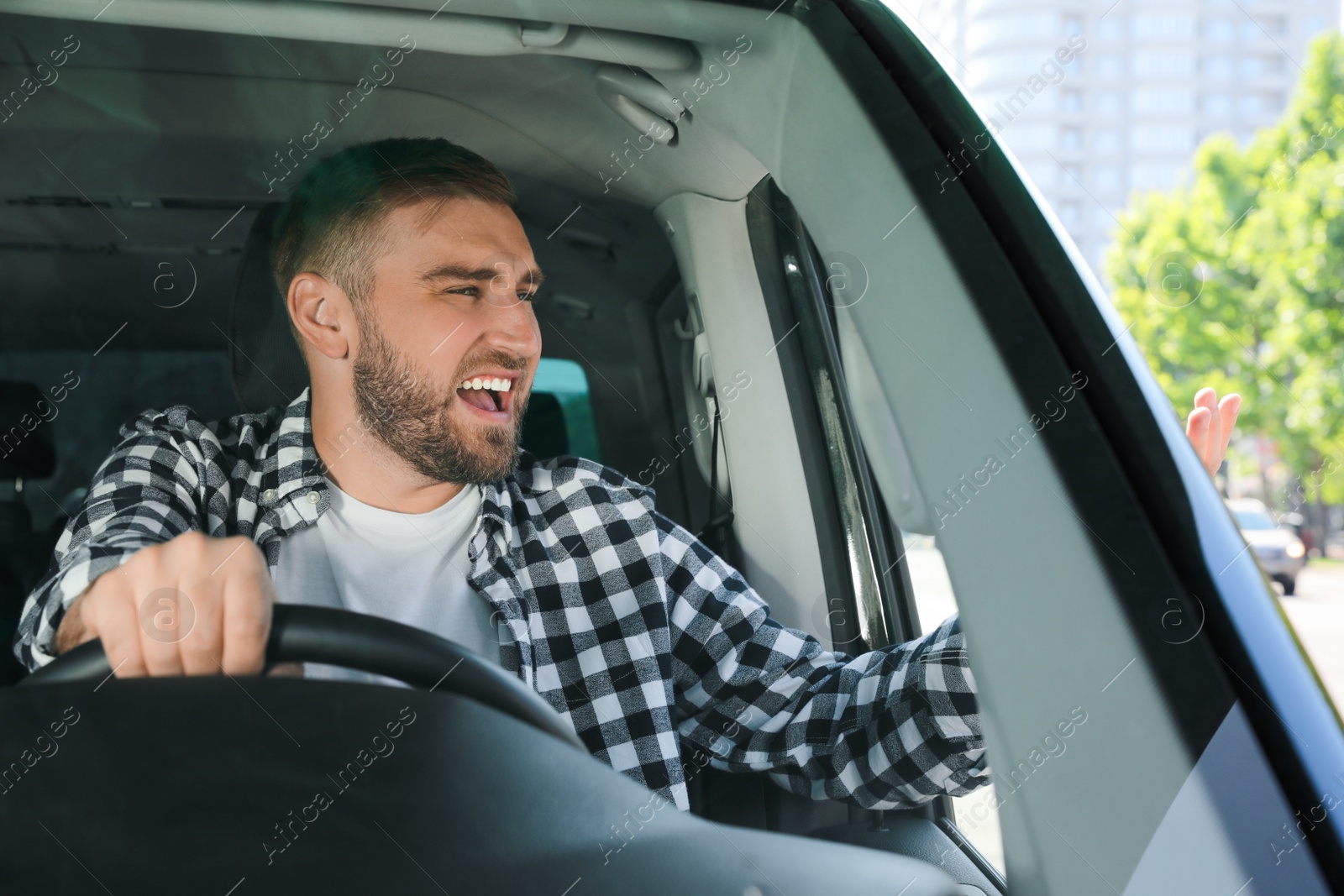 Photo of Emotional man in car. Aggressive driving behavior