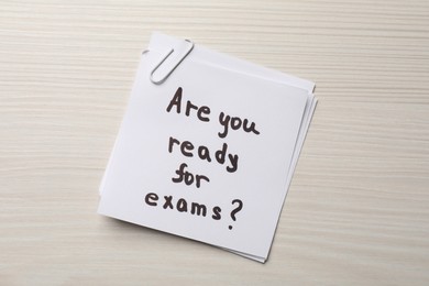 Photo of Note with question Are You Ready For Exams? on white wooden table, top view