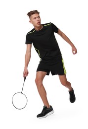 Young man playing badminton with racket on white background